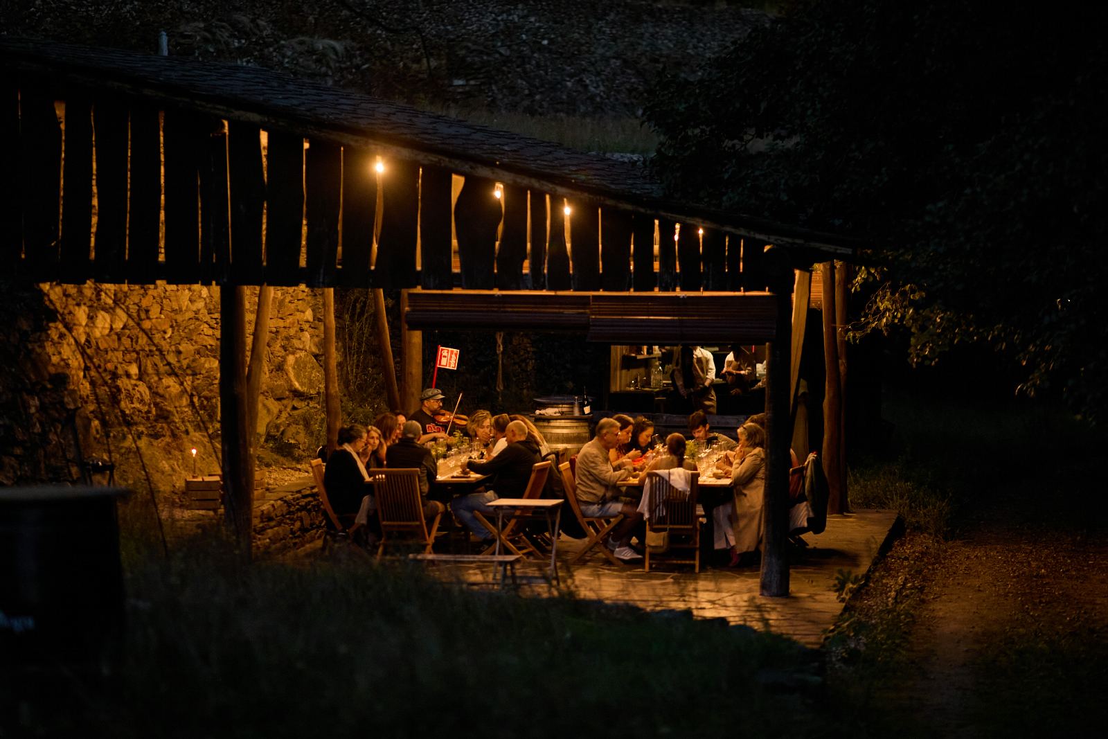 A cea de noite baixo un tellado de madeira, con luces